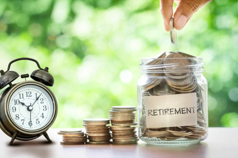 Hand putting Coins in glass jar with retro alarm clock  for time